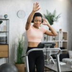 African american women with short curly hair in sports clothes and sneakers, listening music