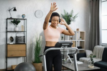 African american women with short curly hair in sports clothes and sneakers, listening music