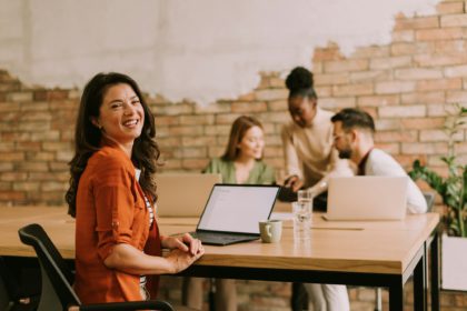 Business woman working on laptop with her young multiethnic startup team in the modern office