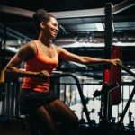 Fitness female using air bike for cardio workout at crossfit gym