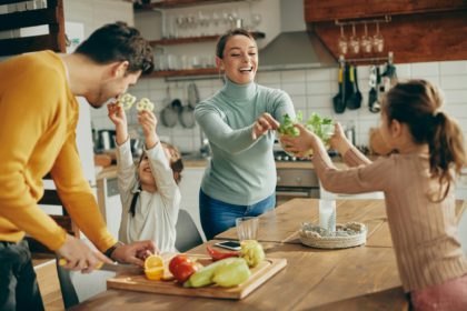 Happy family having fun while preparing healthy food in the kitchen.