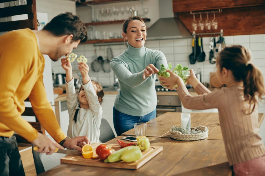 Happy family having fun while preparing healthy food in the kitchen.