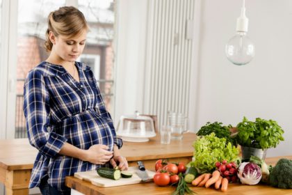 Pregnant woman chopping vegetables