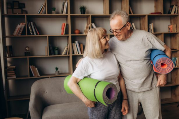 Senior couple is doing fitness training at home.Standing with fitness yoga carpets. Healthy l