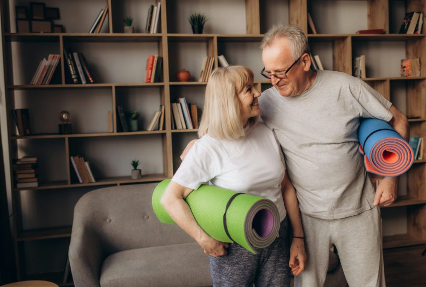 Senior couple is doing fitness training at home.Standing with fitness yoga carpets. Healthy l